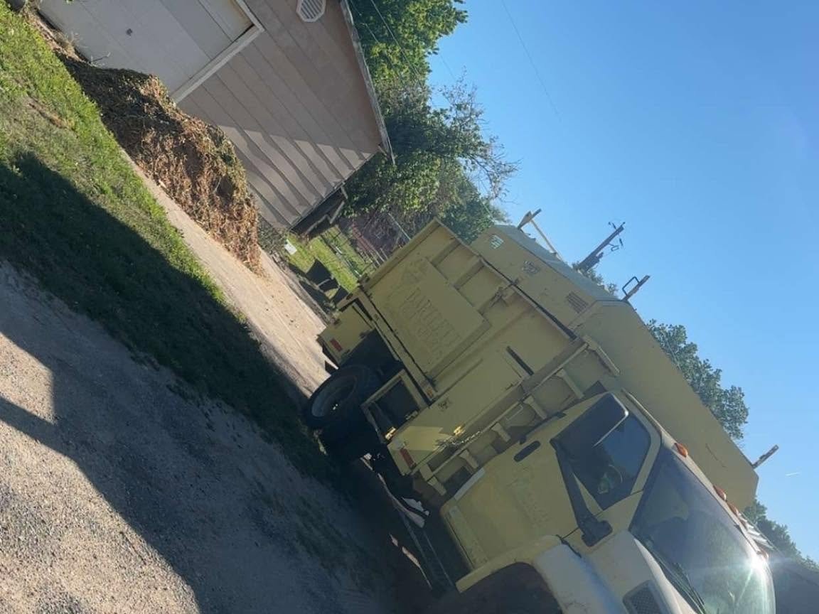 A yellow truck is parked in front of a house